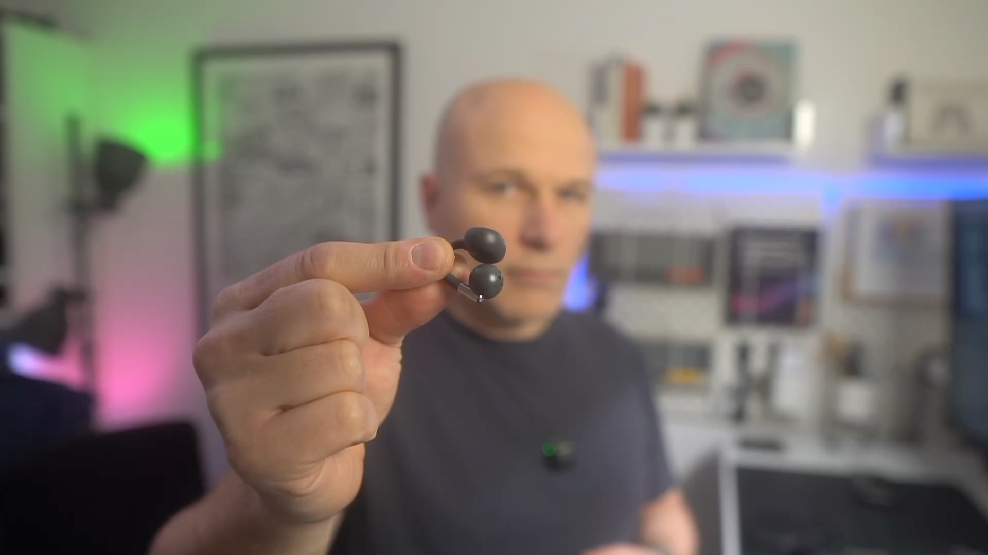 holding a SoundPEATS Clip1 earphone up